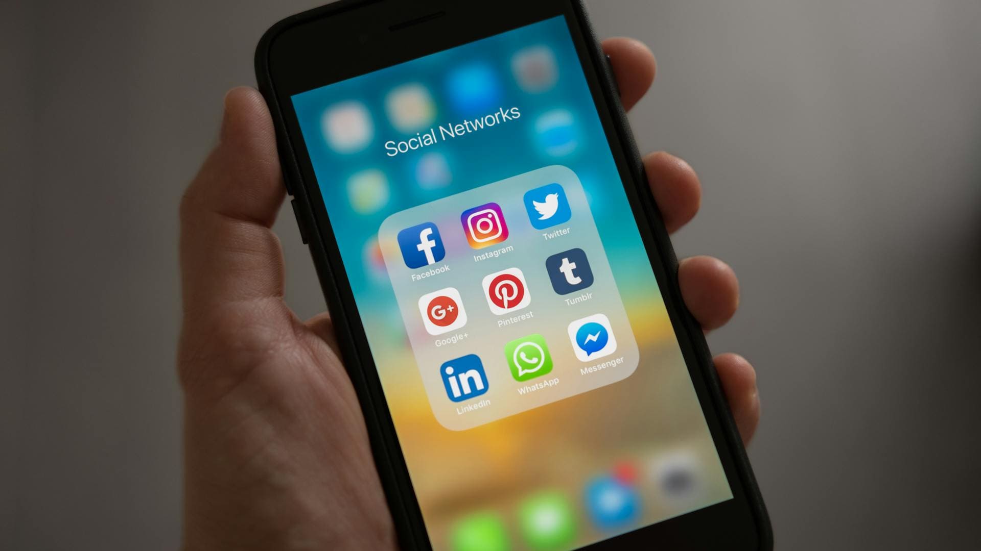 E-Commerce Developer; The image shows a close-up of a hand holding a smartphone with various social media apps open.  The apps include Facebook, Instagram, and Twitter.  The phone also has a chat window open, but the content of the chat is not visible.